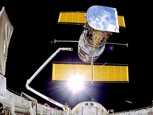 Il telescopio spaziale Hubble si dispiega dal braccio dello space shuttle in orbita terrestre