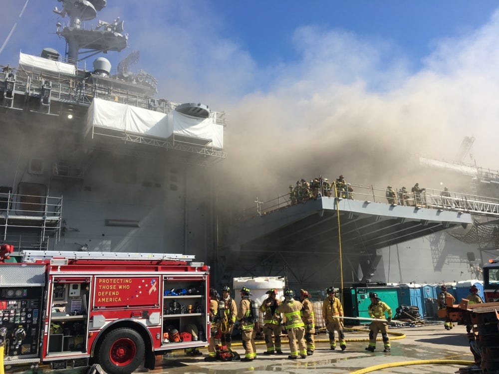 I vigili del fuoco combattono contro un incendio a bordo della nave d'assalto anfibia della US Navy USS Bonhomme Richard