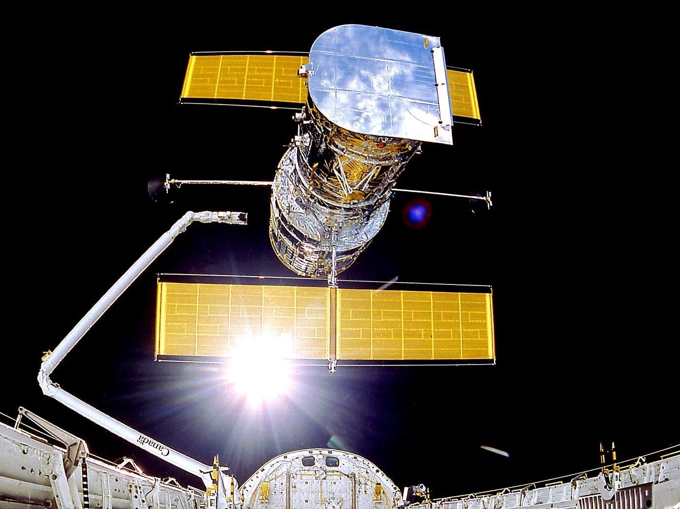 Il telescopio spaziale Hubble si dispiega dal braccio dello space shuttle in orbita terrestre