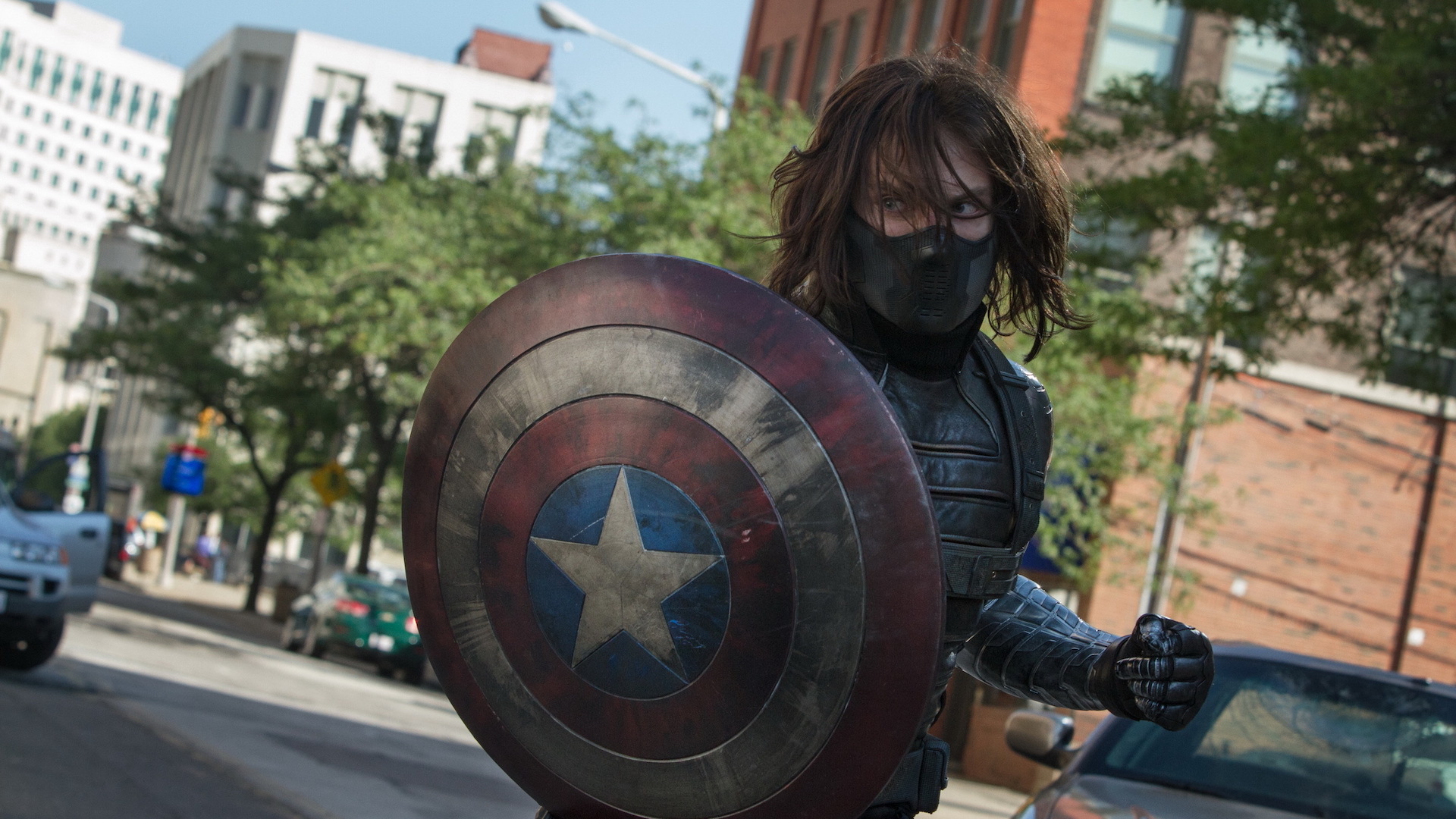 Bucky Barnes (Sebatian Stan) nei panni del soldato d'inverno; mascherato, armato e con in mano lo scudo di Capitan America da usare contro di lui come arma.