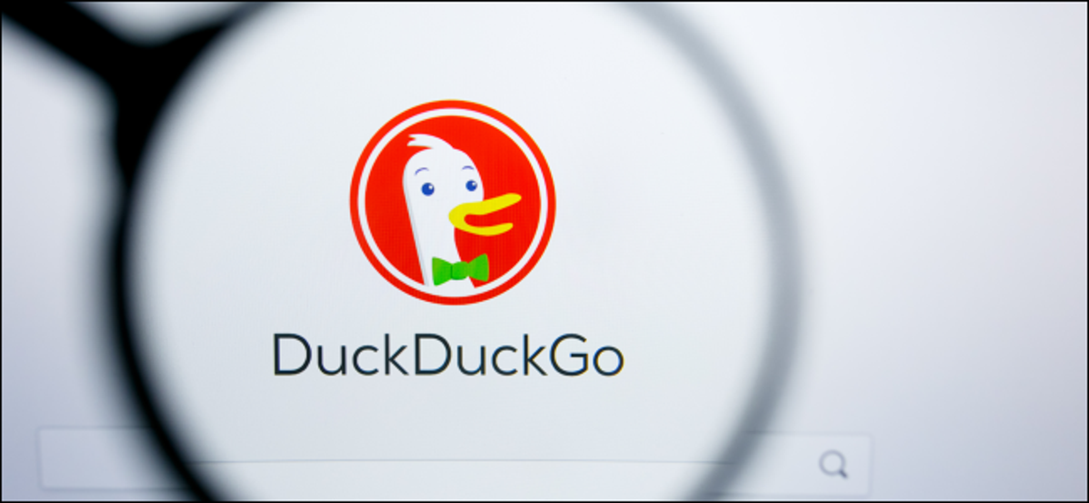 Il logo DuckDuckGo sotto una lente d'ingrandimento.