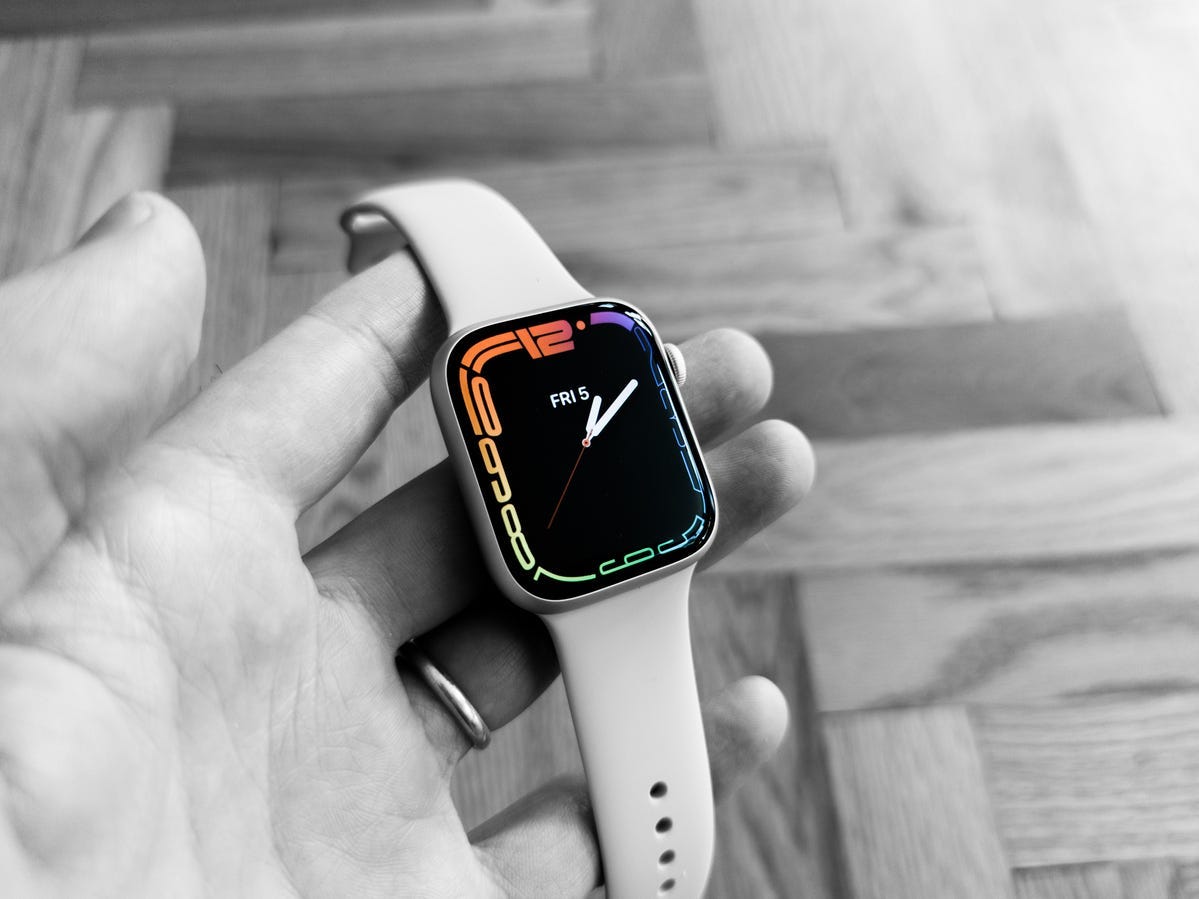 Una foto in bianco e nero di una mano che tiene l'Apple Watch Series 7