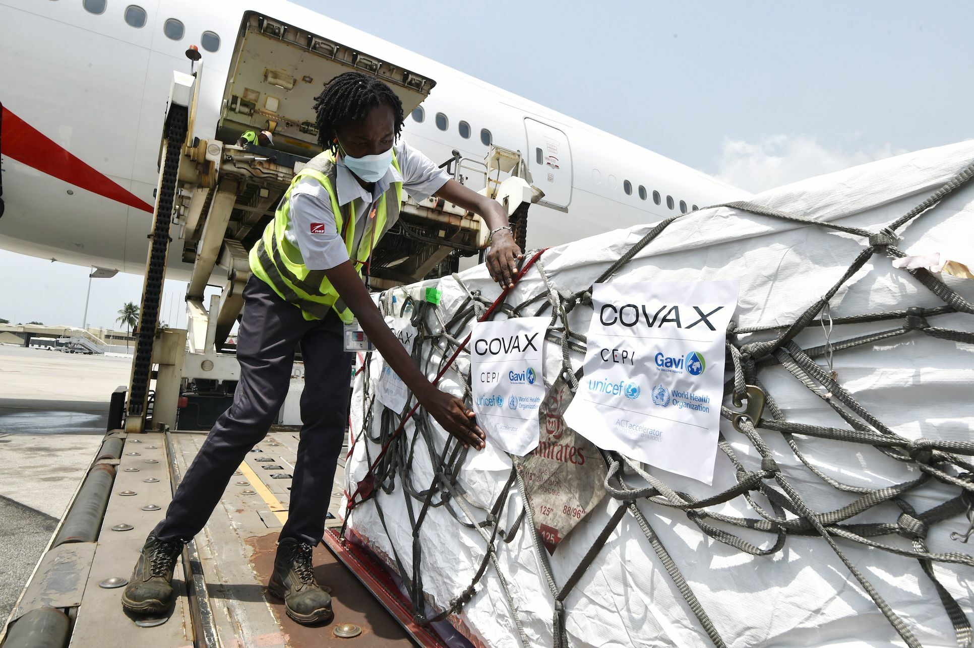 Un lavoratore di una compagnia aerea scarica vaccini COVID-19 in Africa