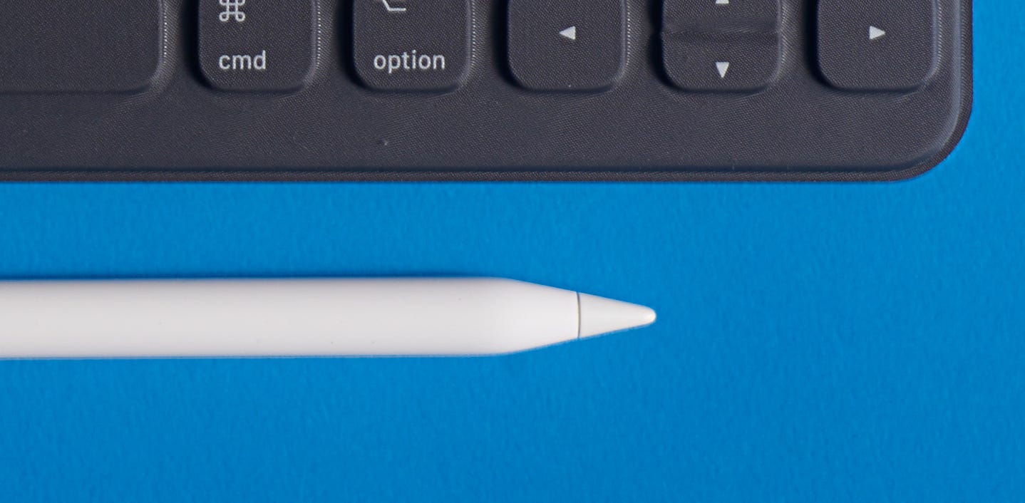 Una Apple Pencil posata accanto alla tastiera di un iPad.