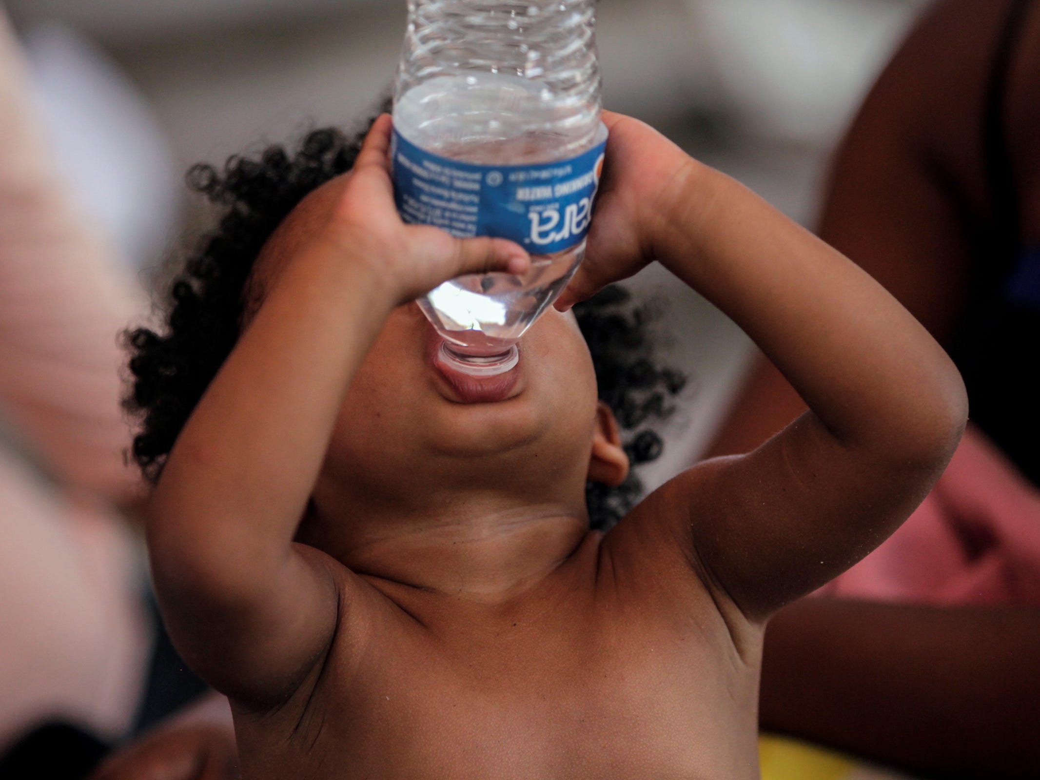 il bambino del bambino beve l'acqua in bottiglia