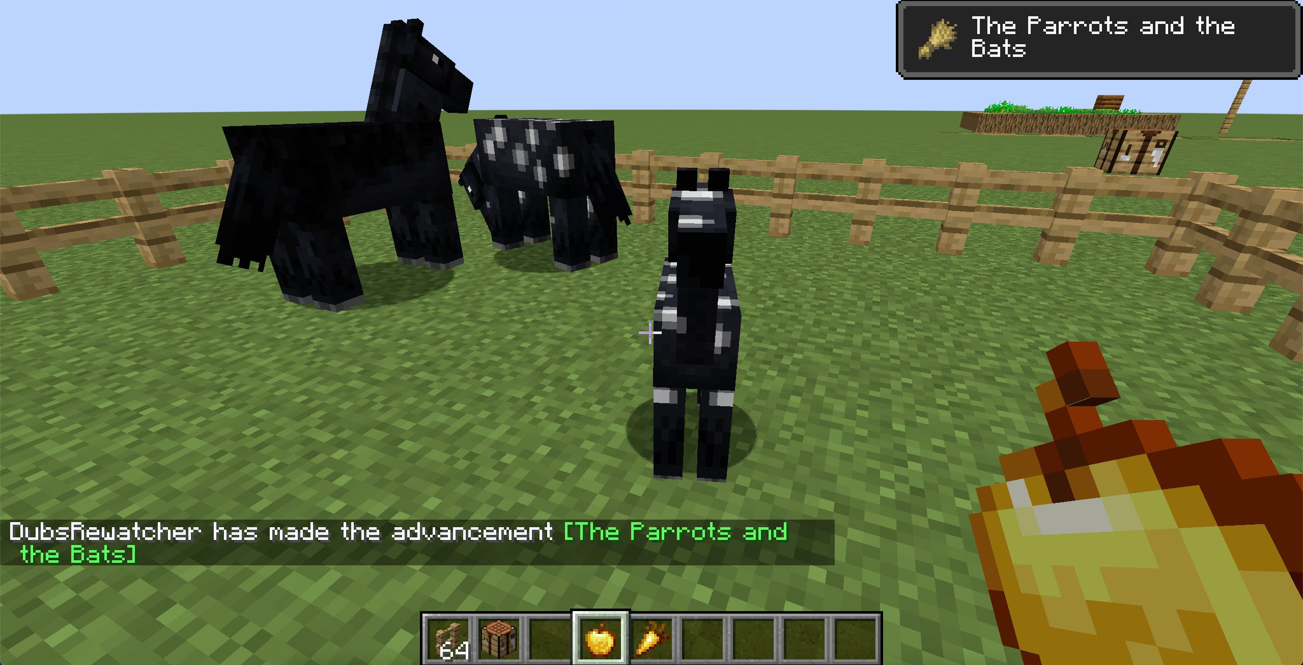 Uno screenshot del gioco Minecraft, che mostra un puledro in piedi vicino a due cavalli adulti.