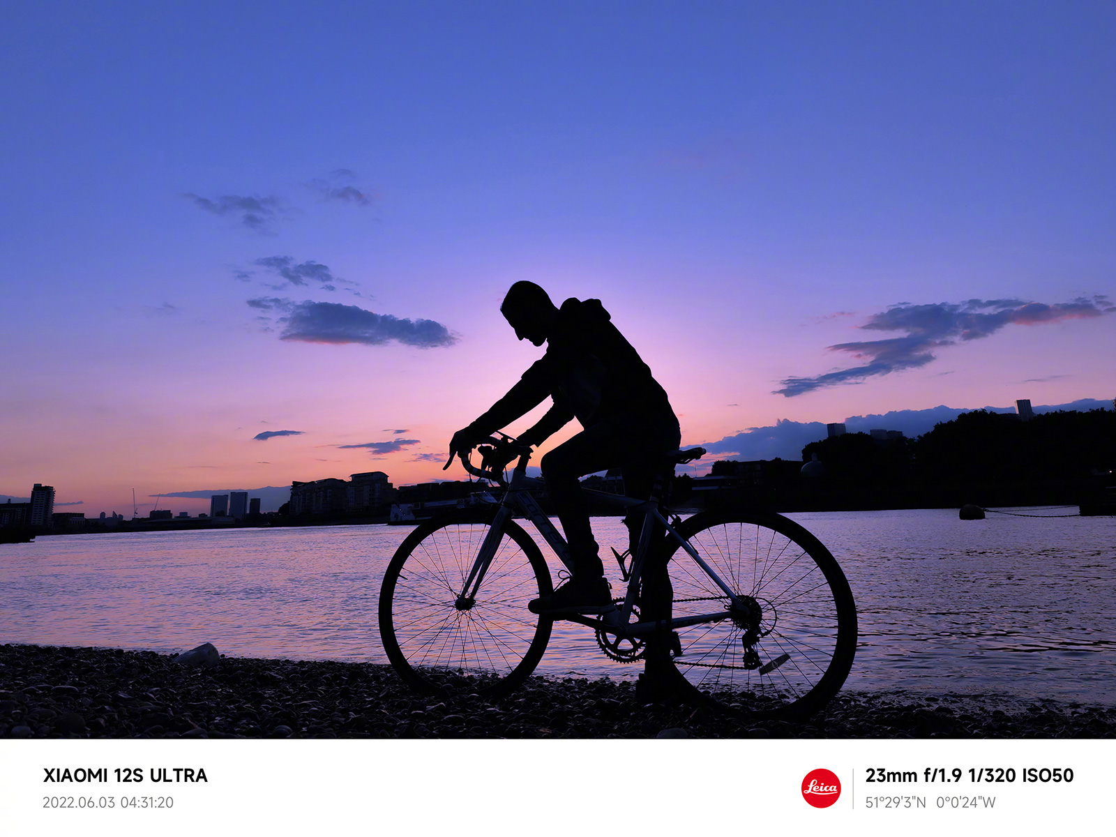 Uno scatto campione realizzato con Xiaomi 12S Ultra, con un ciclista sulla riva di un fiume la mattina presto prima dell'alba.
