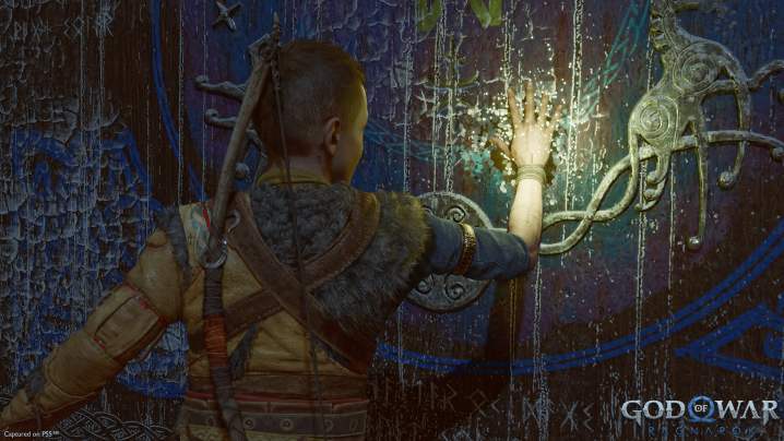 God of War Ragnarok Atreus tocca un murale.