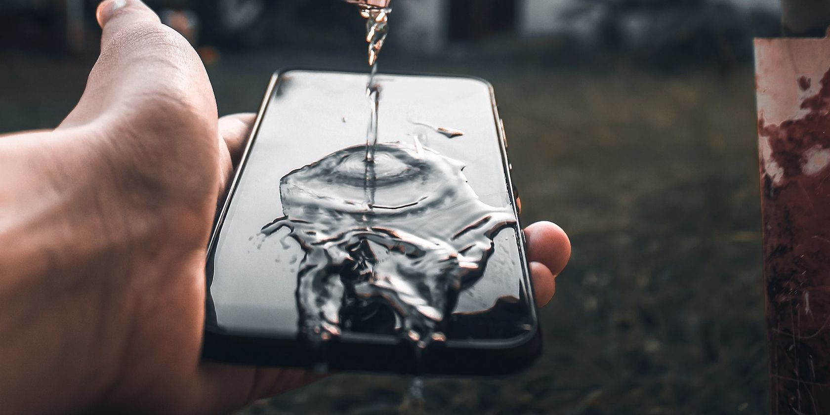 Acqua che scorre sullo schermo di uno smartphone