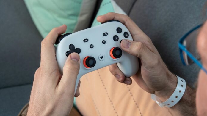 Primo piano del controller Stadia tenuto nelle mani di Russell Holly.